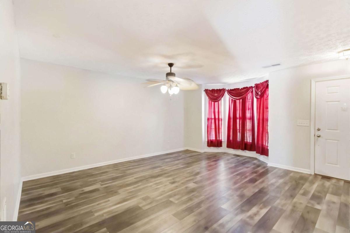 5559 Strathmoor Manor Circle Lithonia, GA 30058 - Photo 3 of 22 a view of a livingroom with a ceiling fan window and a ceiling fan