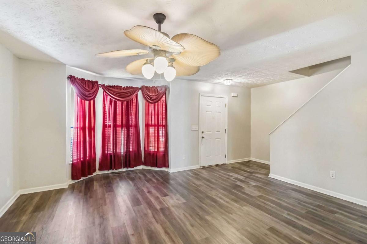5559 Strathmoor Manor Circle Lithonia, GA 30058 - Photo 4 of 22 a view of a room with a chandelier fan and wooden floor
