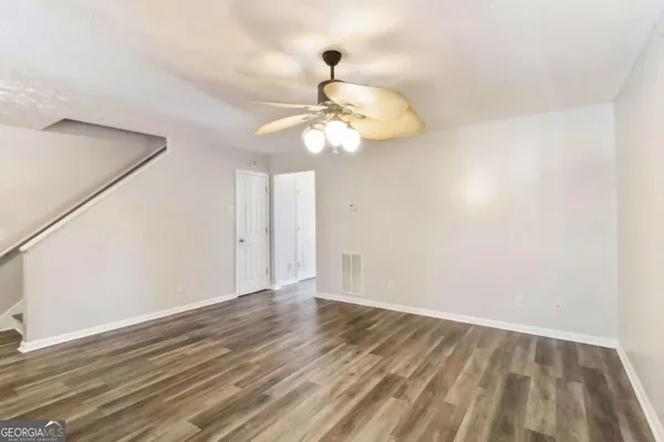 a view of a room with wooden floor and ceiling fan