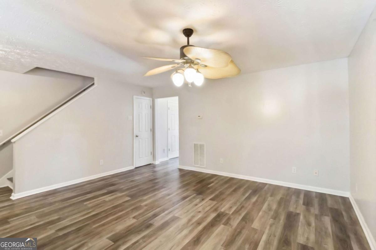 5559 Strathmoor Manor Circle Lithonia, GA 30058 - Photo 5 of 22 a view of a room with wooden floor and ceiling fan