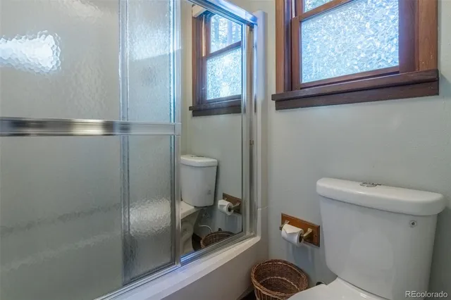 a bathroom with a toilet and a shower