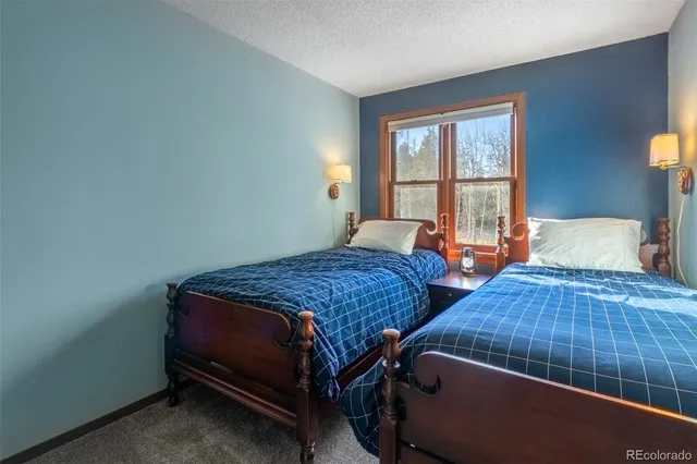 a bedroom with 2 bed and a window