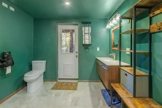 a bathroom with a toilet sink and mirror