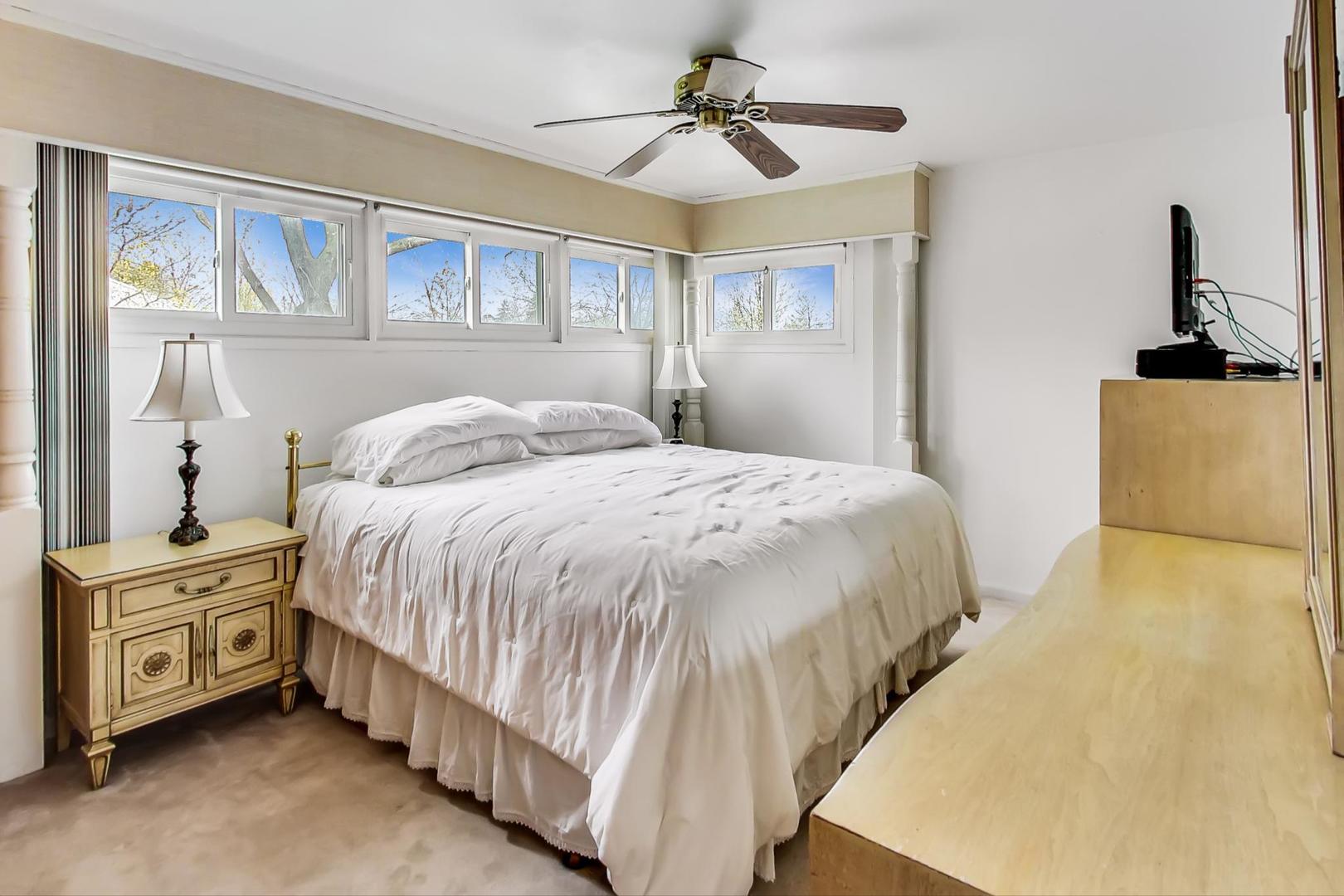 322 Voltz Road Northbrook, IL 60062 - Photo 9 of 21 a bedroom with a bed and a chandelier