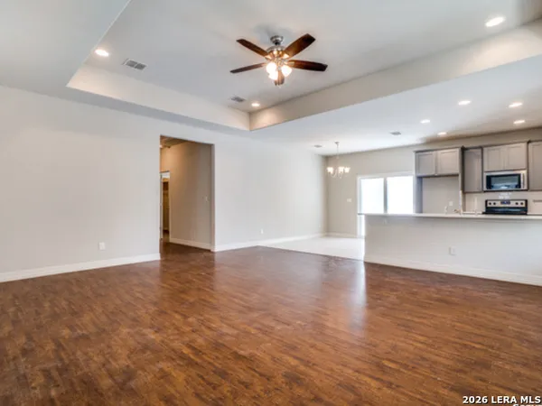a view of an empty room with kitchen and kitchen area