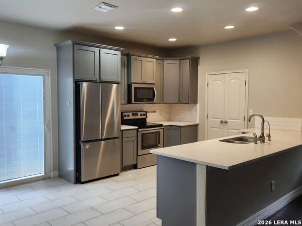 a kitchen with kitchen island a sink appliances and cabinets