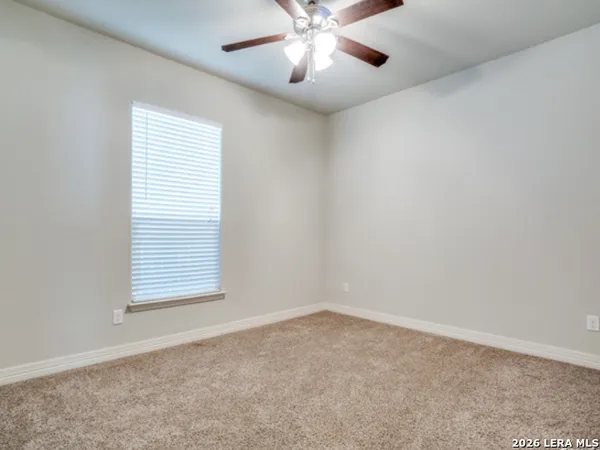 an empty room with a window and a fan