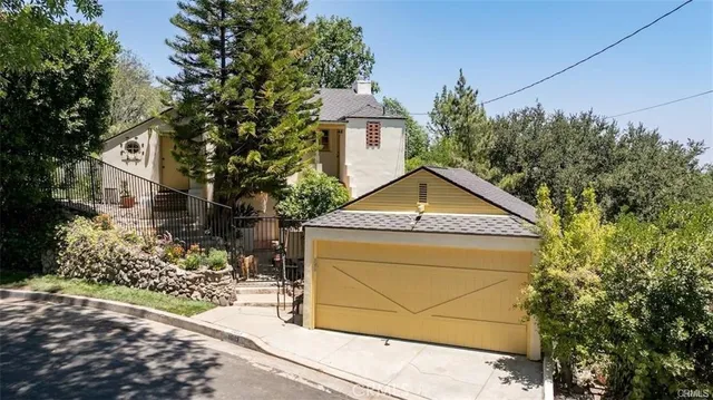 a yellow and red house with a tree in front of it