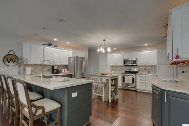 a kitchen with a center island appliances and cabinets