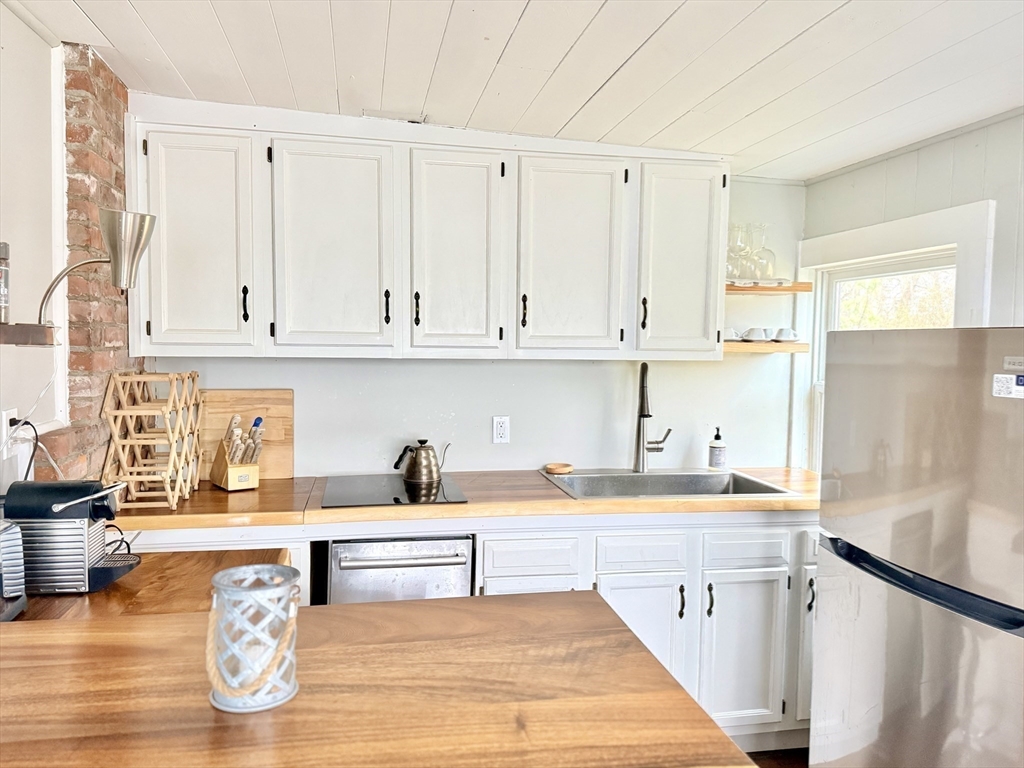 43 Pond Street, Unit 11 Dennis, MA 02670 - Photo 15 of 37 a kitchen with white cabinets and sink