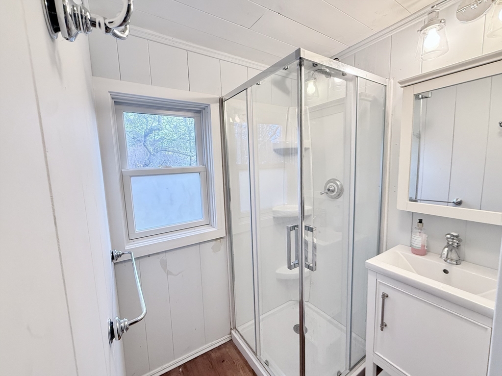 43 Pond Street, Unit 11 Dennis, MA 02670 - Photo 24 of 37 a bathroom with a shower sink and mirror