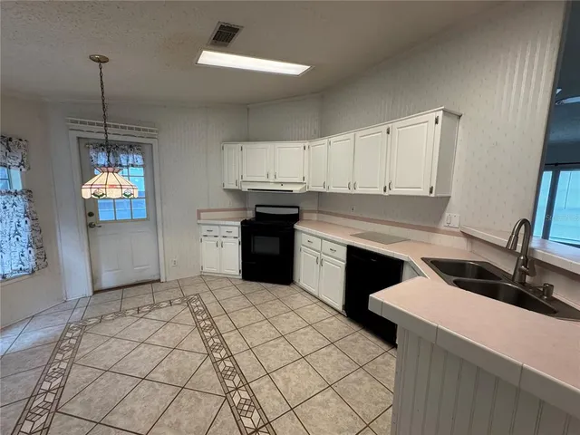 a kitchen with a stove sink and cabinets