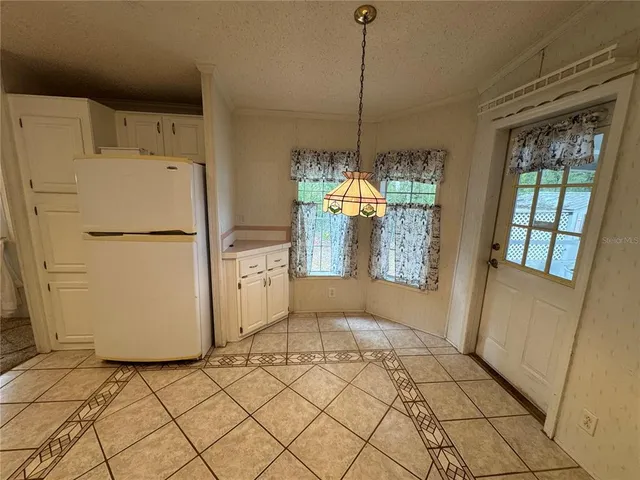 a white refrigerator freezer and a wooden floor in a kitchen