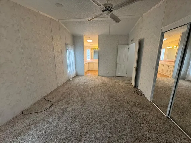 a view of a big room with wooden floor and windows