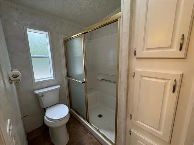 a bathroom with a toilet and a shower