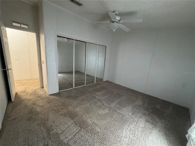 an empty room with closet and windows