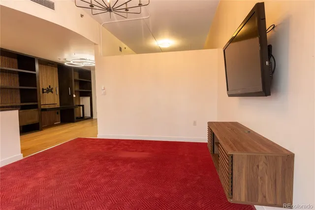 a view of an empty room with cabinet and a window