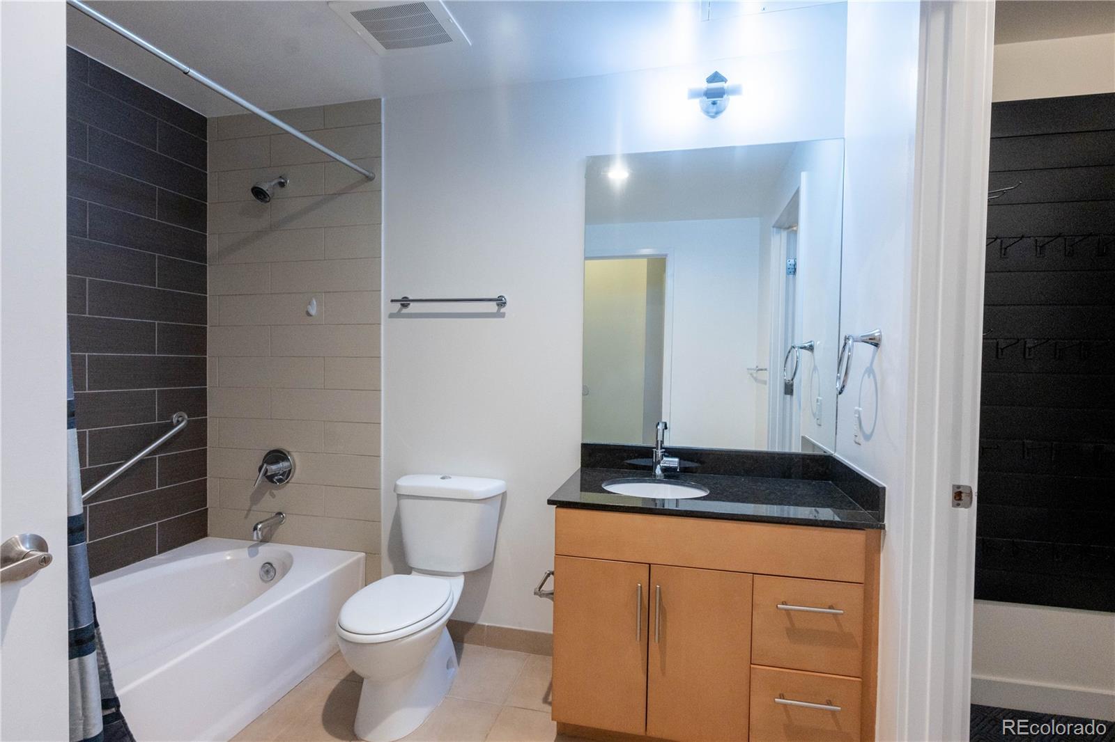 891 14th Street, Unit 2105 Denver, CO 80202 - Photo 22 of 50 a bathroom with a granite countertop sink toilet and shower