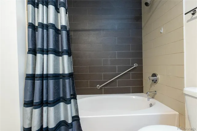 an empty room with a flat screen tv and staircase