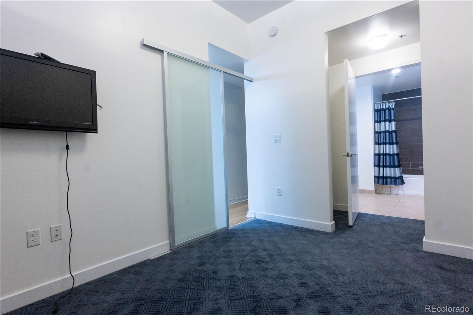 891 14th Street, Unit 2105 Denver, CO 80202 - Photo 25 of 50 an empty room with a flat screen tv and staircase