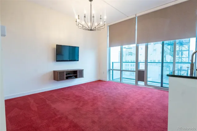a view of an empty room with a window and a flat screen tv