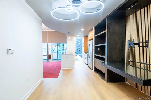 a kitchen with stainless steel appliances kitchen island granite countertop a refrigerator a stove and a sink with wooden floor