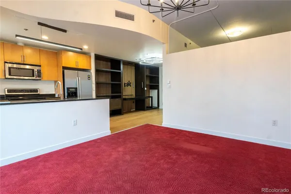 a view of a kitchen with a refrigerator a microwave and a sink