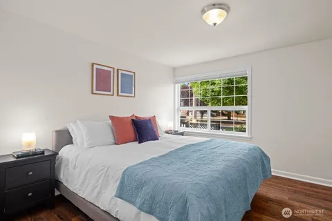 a large bed sitting in a bedroom next to a window and a lamp