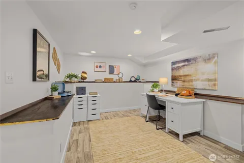 a kitchen with stainless steel appliances a stove a refrigerator sink and white cabinets with wooden floor