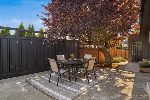 a view of a patio with table and chairs and wooden fence