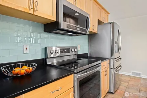 a kitchen with stainless steel appliances granite countertop a stove and a microwave