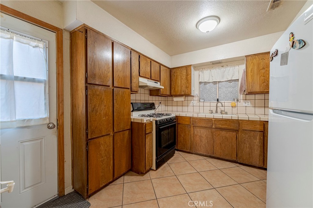 2394 Lance Street Merced, CA 95348 - Photo 11 of 34 a kitchen with stainless steel appliances granite countertop a refrigerator sink and cabinets