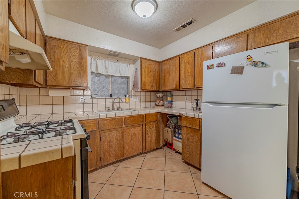 2394 Lance Street Merced, CA 95348 - Photo 12 of 34 a kitchen with stainless steel appliances a refrigerator sink and cabinets