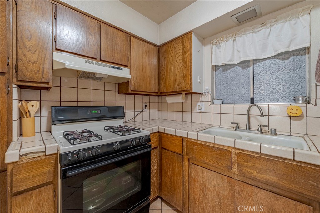 2394 Lance Street Merced, CA 95348 - Photo 13 of 34 a kitchen with granite countertop a stove sink and cabinets