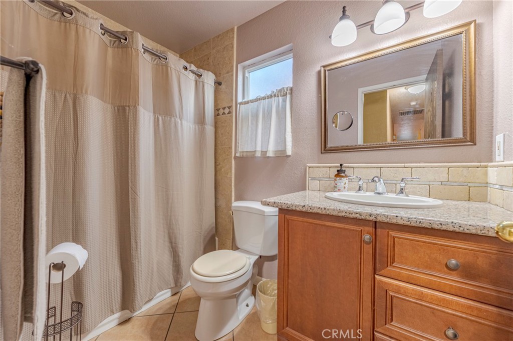 2394 Lance Street Merced, CA 95348 - Photo 24 of 34 a bathroom with a granite countertop sink toilet and mirror
