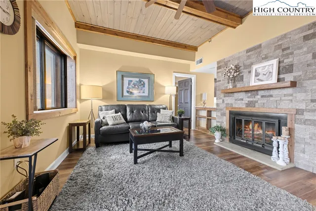 a view of a dining room and livingroom with furniture wooden floor a chandelier