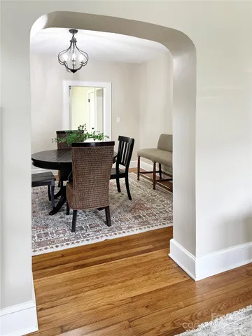 a living room with dining room and wooden floor