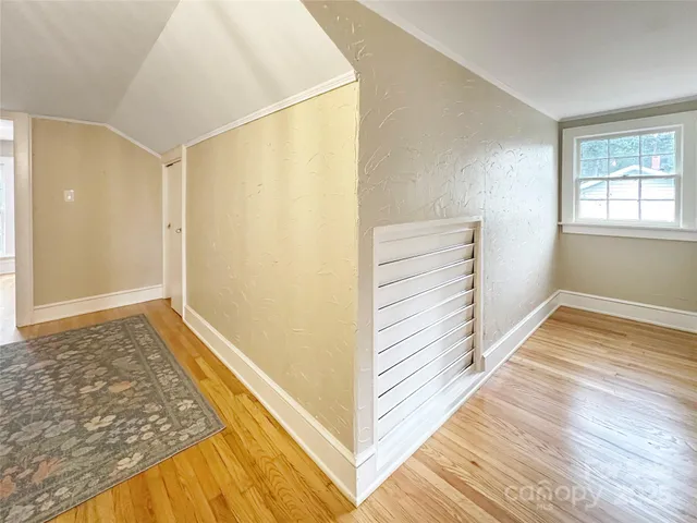 a view of a room with wooden floor and white walls
