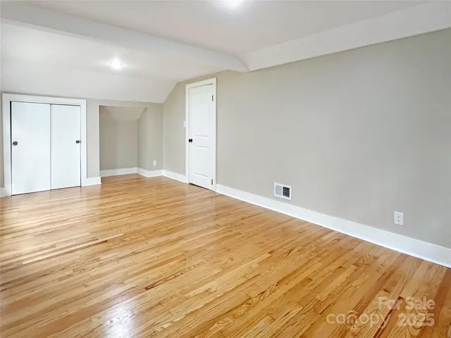 a view of empty room with wooden floor