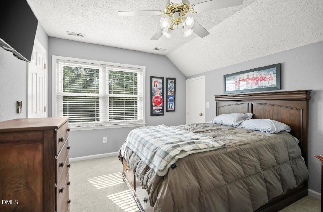 5780 McArthur Road Broadway, NC 27505 - Photo 27 of 40 a bedroom with a large bed and a chandelier