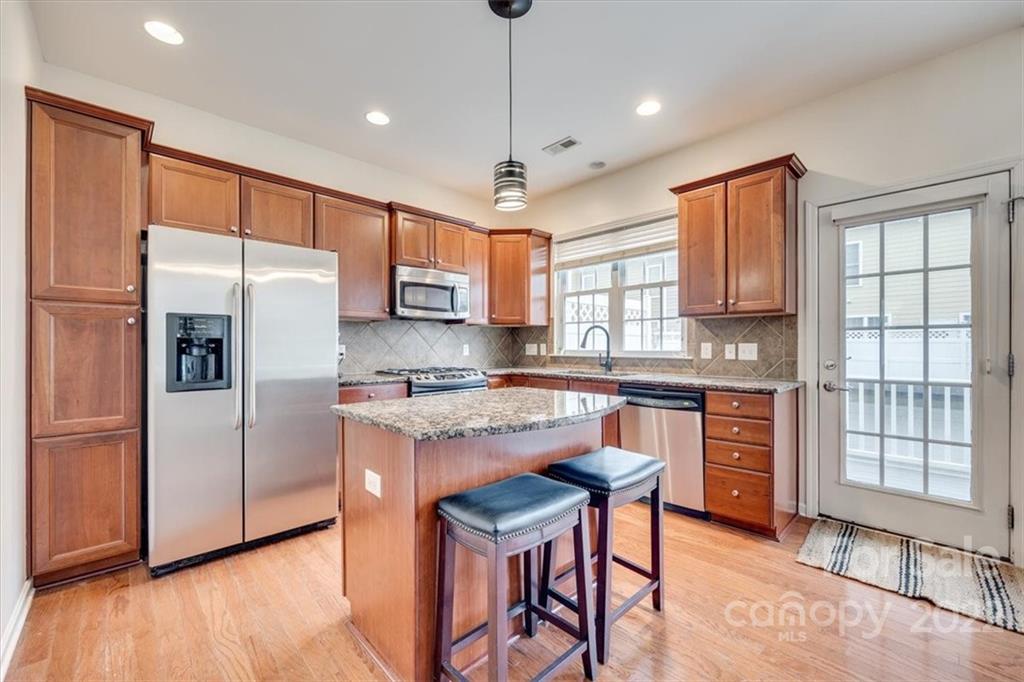 927 Lyndley Drive Fort Mill, SC 29708 - Photo 12 of 48 a kitchen with stainless steel appliances granite countertop a refrigerator a sink dishwasher a stove and white countertops with wooden floor