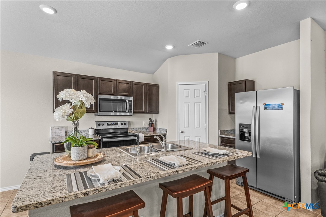 1006 Rosa Parks Drive Killeen, TX 76543 - Photo 11 of 34 a kitchen with stainless steel appliances kitchen island granite countertop a refrigerator and a stove top oven