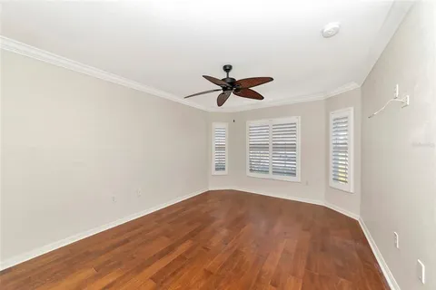 a view of a room with wooden floor and ceiling fan