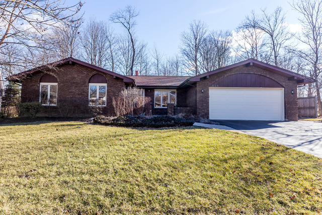 a front view of house with yard and trees around