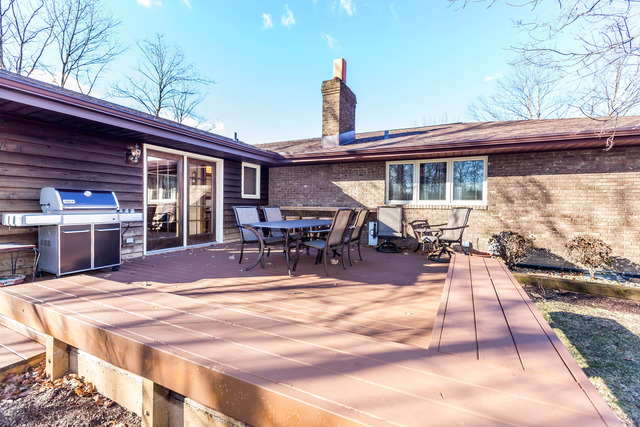 809 Overlook Drive Frankfort, IL 60423 - Photo 22 of 24 a view of a patio with dining table and chairs with wooden floor and fence