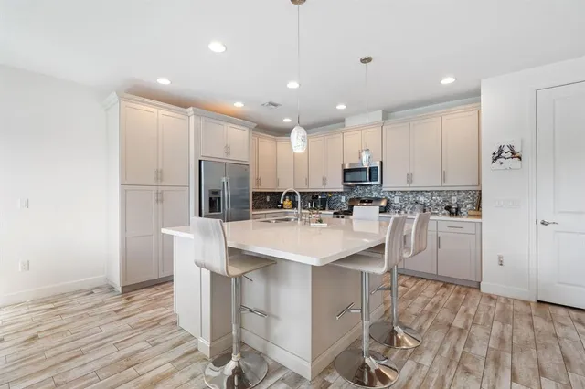 a kitchen with kitchen island white cabinets and stainless steel appliances