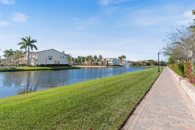 a view of a lake with a yard and large trees