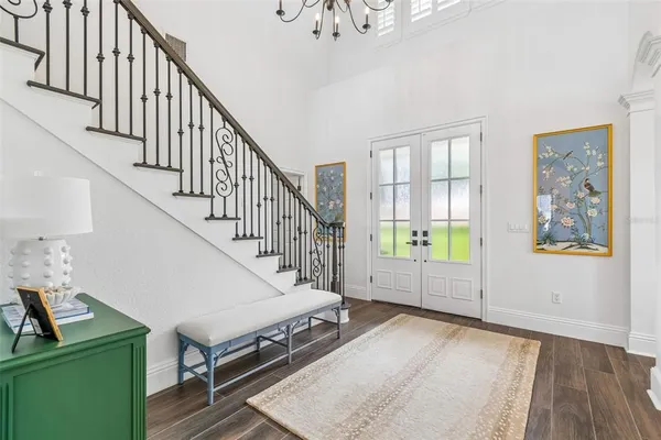 a view of a dining room with furniture a chandelier and wooden floor
