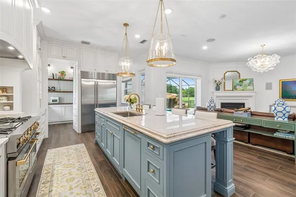 a kitchen with white cabinets and wooden floor