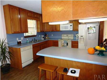 1950 Smyers Road Cantonment, FL 32533 - Photo 13 of 25 a kitchen with stainless steel appliances a sink a stove top oven a counter space and cabinets